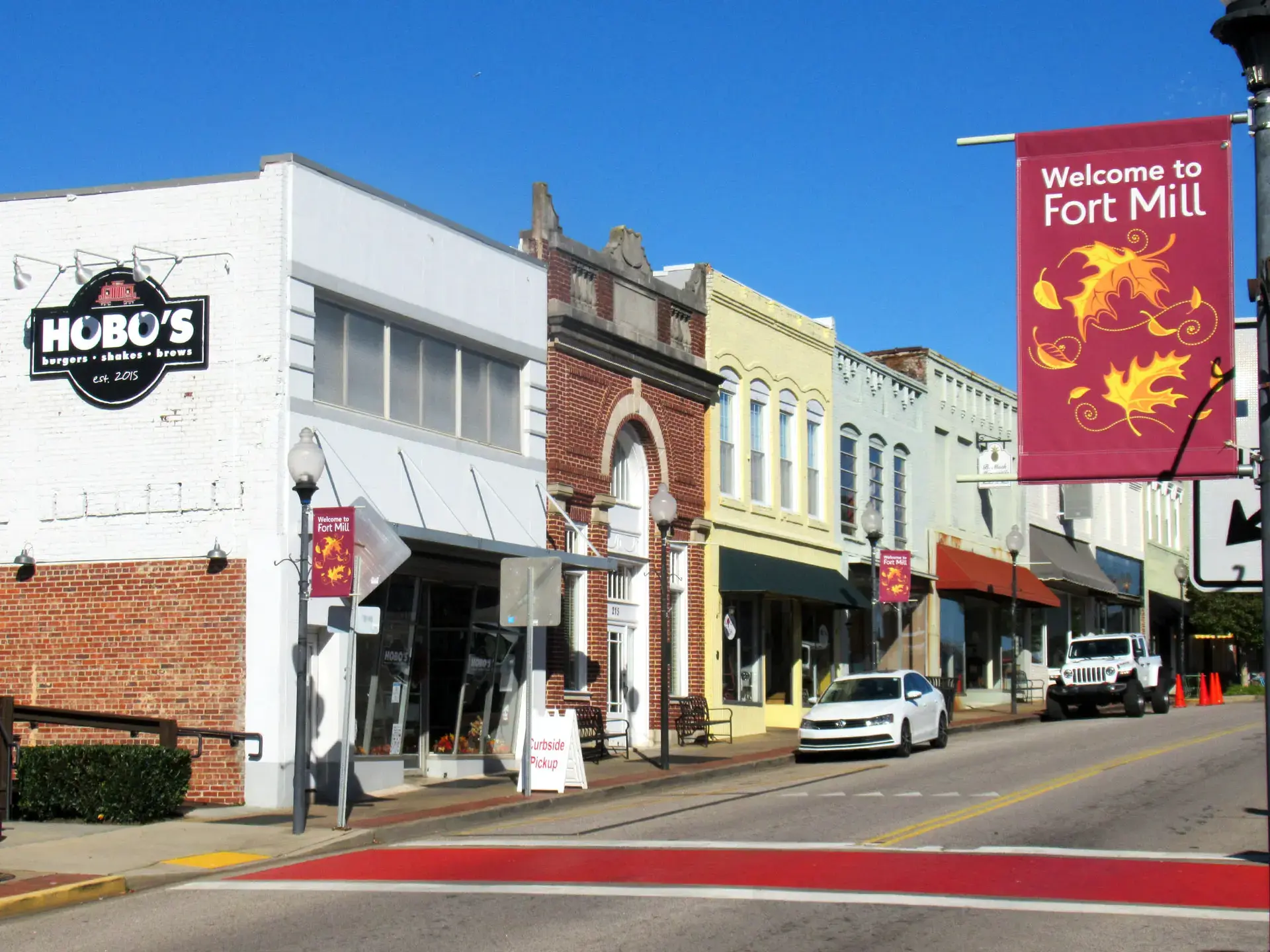 Colorful Main Street storefronts and a Welcome to Fort Mill banner in Fort Mill, SC