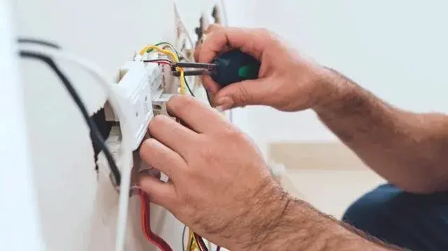 Electrician repairing a wiring connection during an electrical panel repair in Gastonia, NC